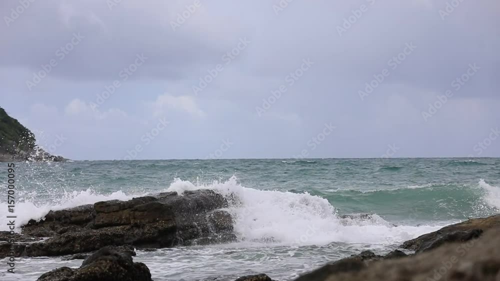 Waves break against a stone on the shore - slow motion Waves break against a stone on the shore - slow motion