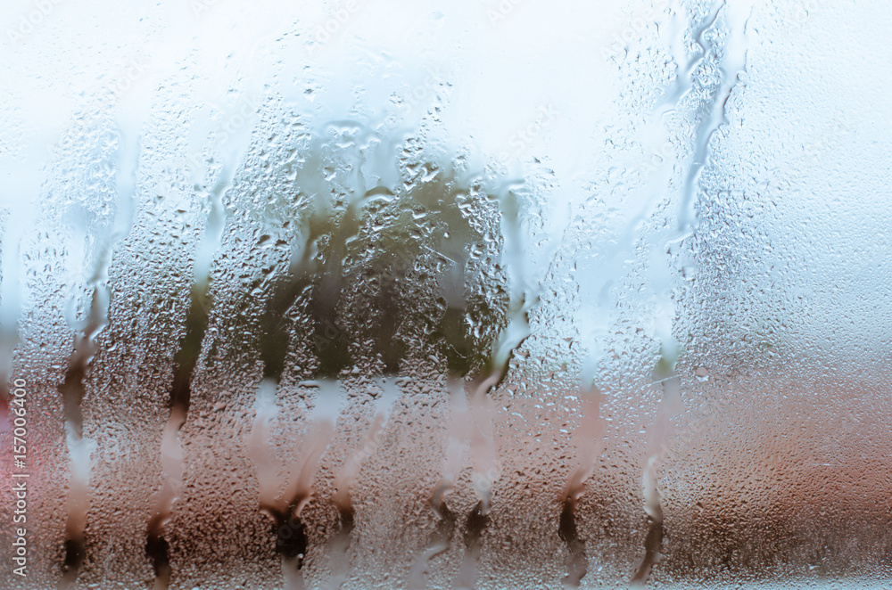 Raindrop Falling On The Window Glass In Blurry Background. Raindrop Falling On The Window Glass In Blurry Background.