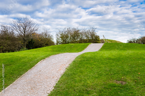 Hillside Gravel Path under Blue Sky with Clouds
