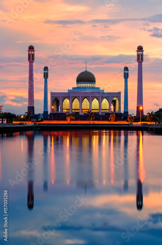 silhouette central mosque songkhla Thailand with sun flare effect and colorful sky background on sunset time and water reflection.