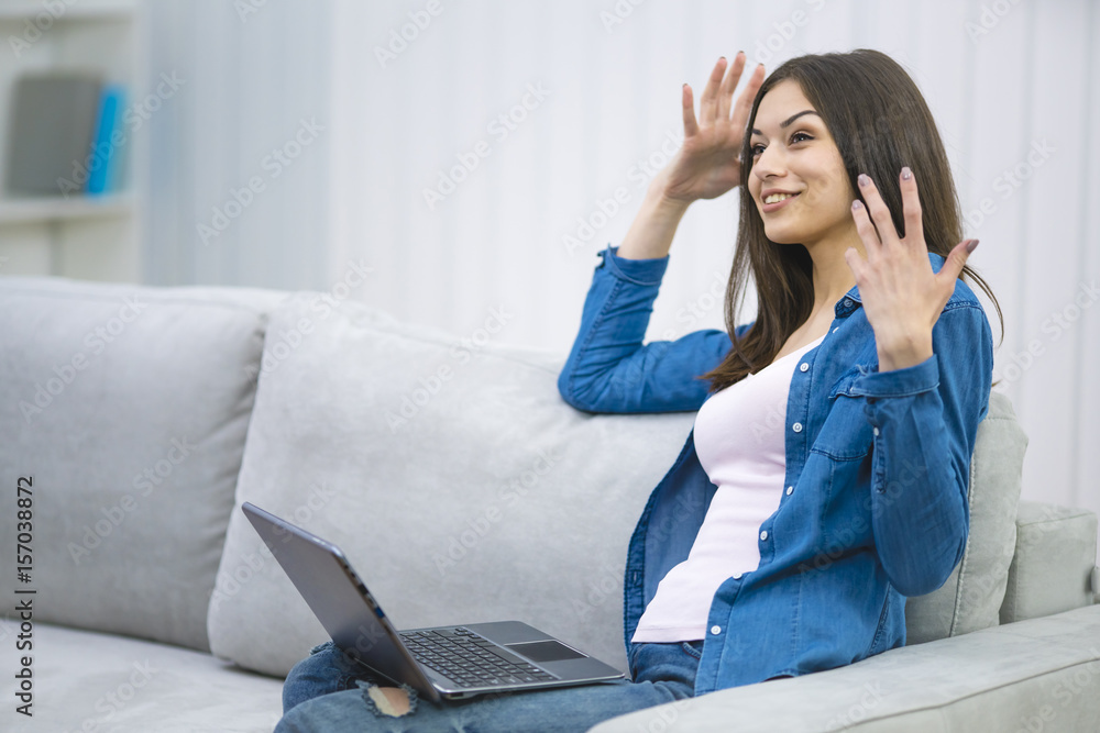 The happy woman with a laptop sin on the sofa The happy woman with a laptop sin on the sofa
