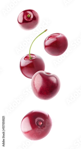 Isolated floating cherries. Falling sweet cherry fruits isolated on white background with clipping path