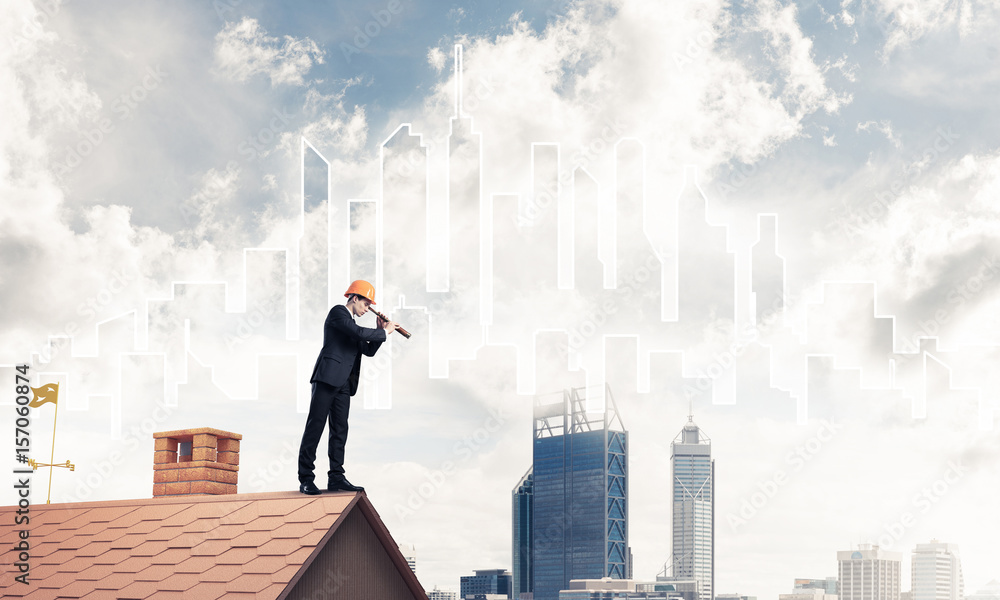 Engineer man standing on roof and looking in spyglass. Mixed med Engineer man standing on roof and looking in spyglass. Mixed med