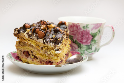 Piece of cake with hazelnuts, teaspoon and cup