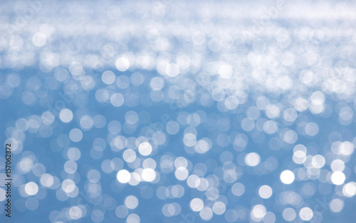 glitzerndes blaues Bokeh, Wasseroberfläche am See mit Textfreiraum für Urlaubssujets etc.