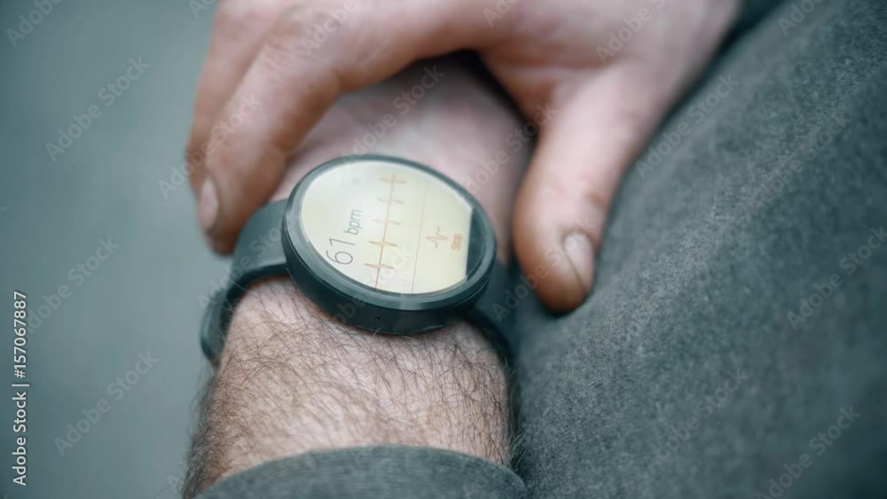 Closeup shot of a man checking his pulse with a smartwatch. Closeup shot of a man checking his pulse with a smartwatch.