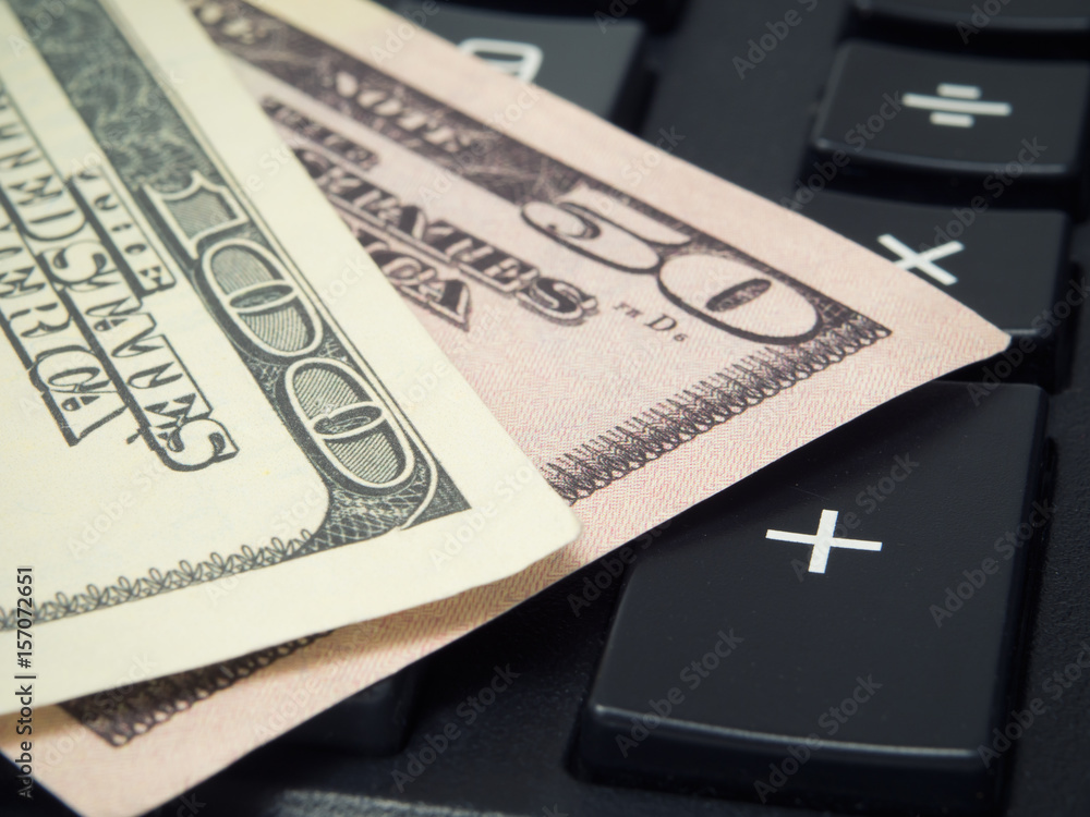 Banknotes of American dollars are on a calculator Banknotes of American dollars are on a calculator