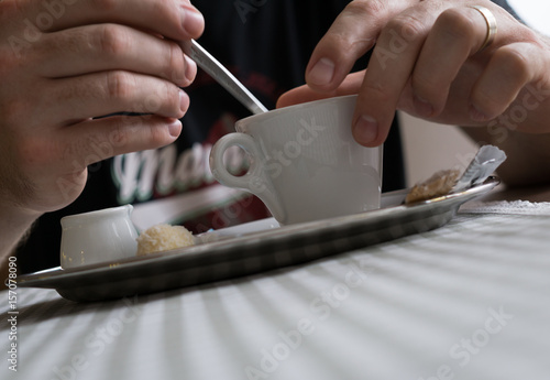 Man's hands mixing his espresso cofee with a spoon. Slovakia
