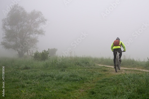 Cyclist on a meadow during foggy morning. Slovakia © Valeria