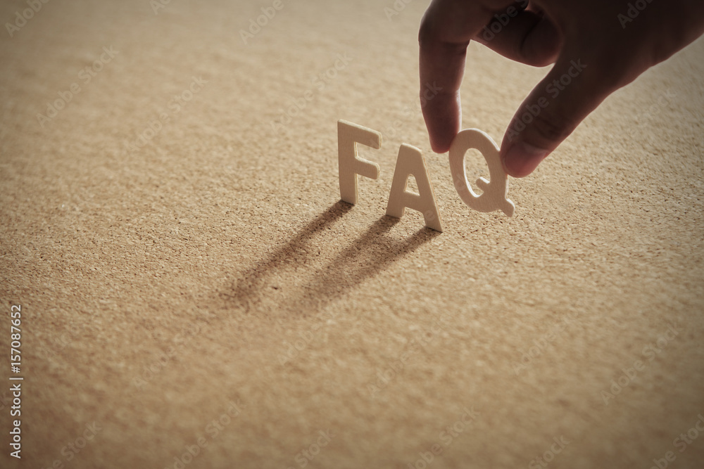 FAQ wood word on compressed board,corkboard with human's finger at Q letter - obrazy, fototapety, plakaty 