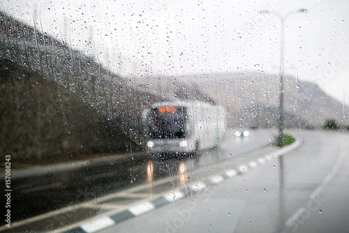 Blurred street scene through car windows with rain drop