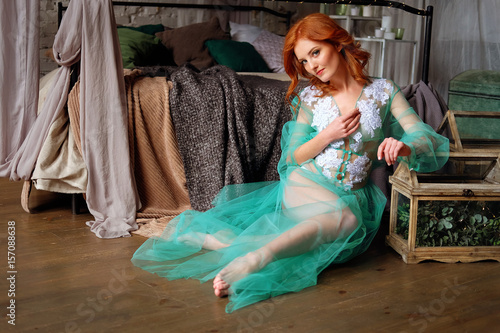 фотографія Tender redhead woman in transparent mint peignoir