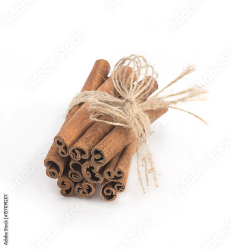 Cinnamon sticks tied with string on white background