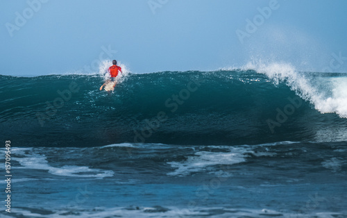 Surfer passing big ocean wave