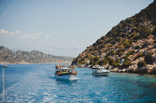 Boats sail in the summer in the Mediterranean Sea with azure water among the mountains and hills
