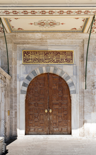 Wooden aged vaulted ornate door and stone wall at Sulaymaniye Mosque, Istanbul, Turkey photo