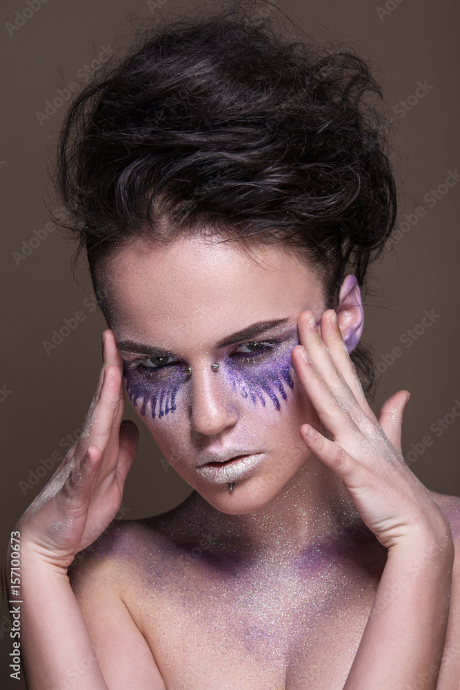 Fashion model with colorful make-up and blue glitter and sparkles on her face and body. Fashion model with colorful make-up and blue glitter and sparkles on her face and body.