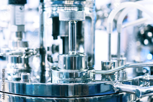 Steel pipes on the body of the pharmaceutical reactor, photo close-up, selective focus.
