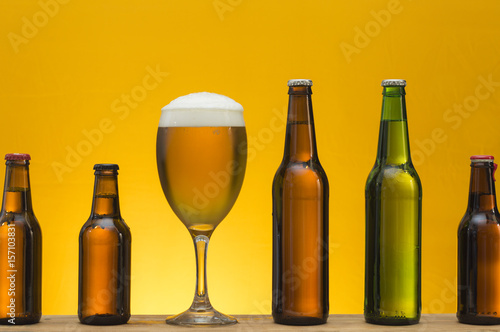 various bottles with different types of beer and a glass of beer