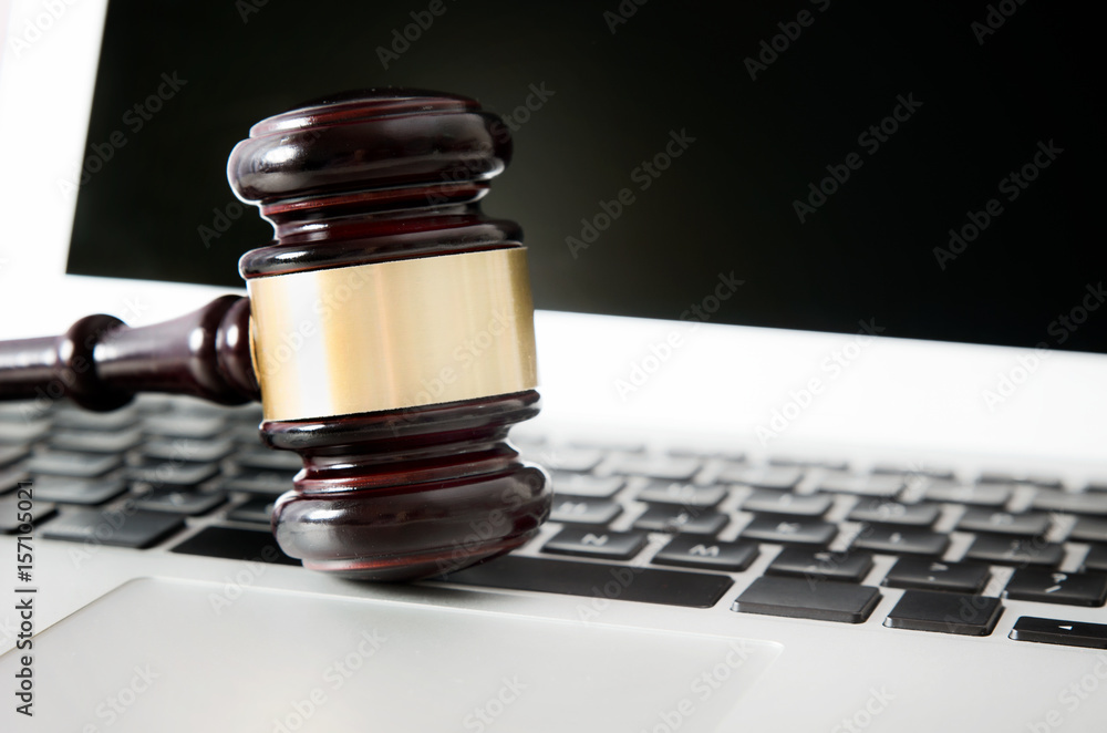 Wooden gavel on laptop keyboard Wooden gavel on laptop keyboard