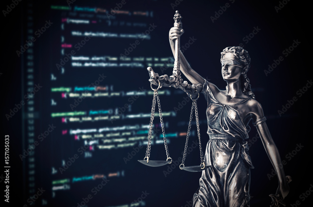 Justice statue with code on monitor device in background Justice statue with code on monitor device in background