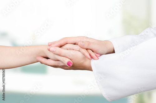 Doctor holding patient hand close up