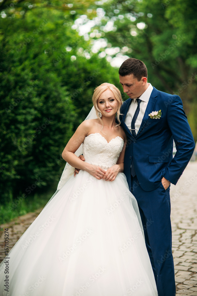 Beautiful couple walking in the park in their wedding day. Sunny weather.
Beautiful couple walking in the park in their wedding day. Sunny weather.