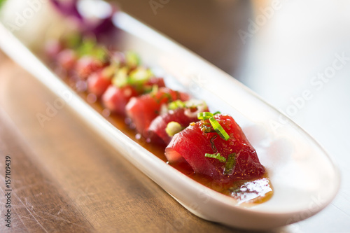 Plate of tuna sashimi. Tuna sashimi is a japanese cuisine dish of thinly sliced fish, in japan it is often served as appetizer in restaurants. It can also be made with other raw meat such as salmon.