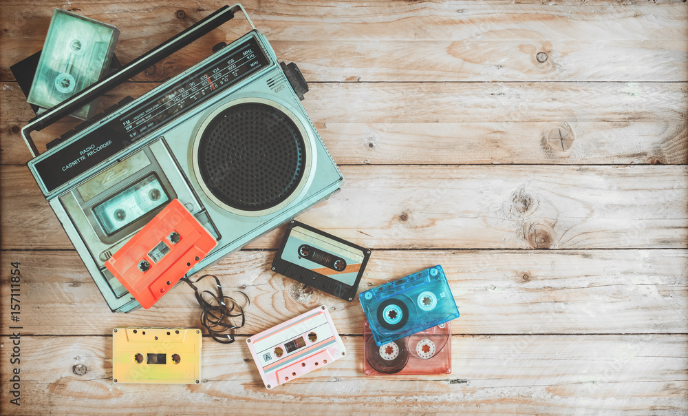 Fototapeta Widok z góry nagłówek bohatera - retro technologia radia magnetofonowa muzyka z retro kaseta z taśmą na stół z drewna. Style efektów kolorowych.