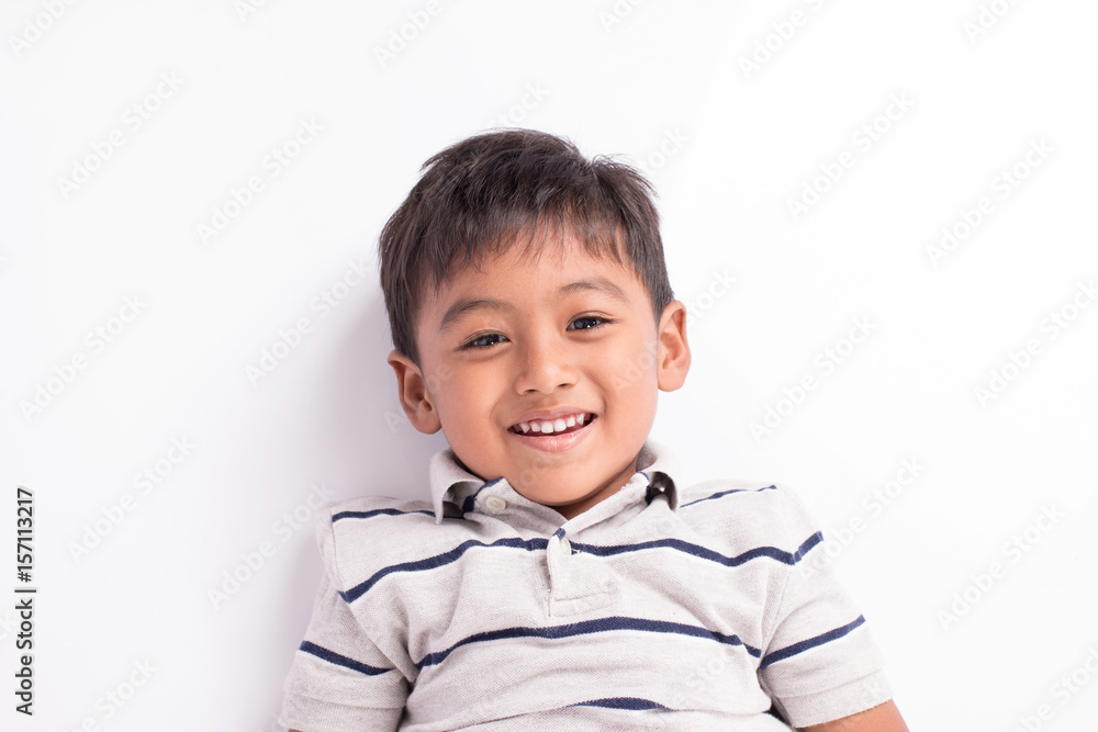close up of cute asian boy smile and lying on floor close up of cute asian boy smile and lying on floor