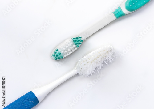 closeup of new and old toothbrush on white background.