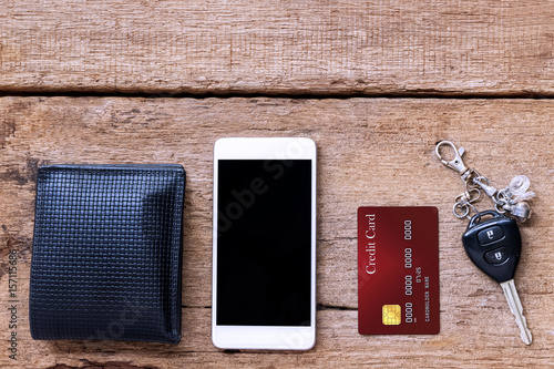 mobile phone and credit card, key and wallet on brown wood table, accessories of businessman.
