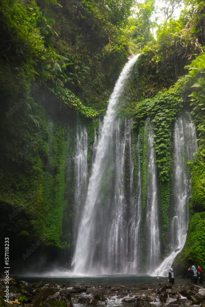 Obraz premium Layered water flows, cool air and green scenery are attractions that tourist can enjoy when they visit Tiu Kelep waterfall in Lombok, Indonesia.