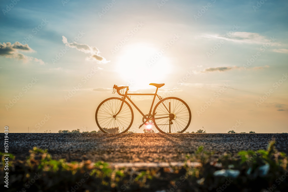 Silhouette of bicycle on the road in front of sunset background. Silhouette of bicycle on the road in front of sunset background.