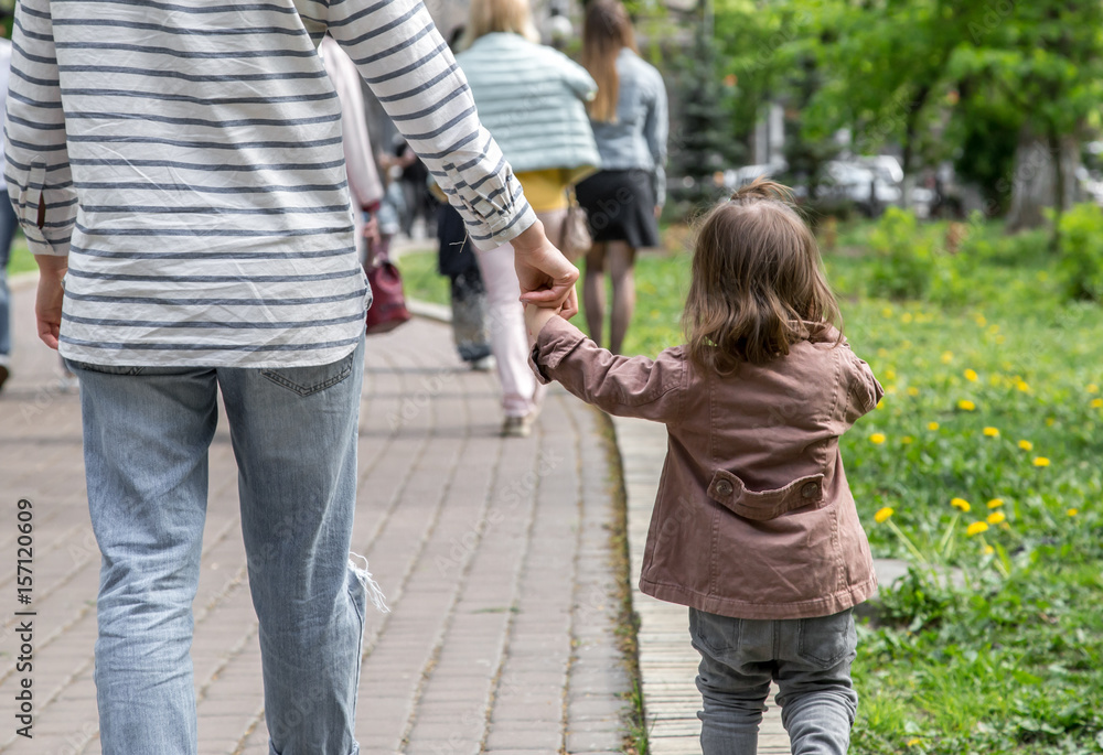 Fototapeta premium a little girl goes hand in hand with mom
