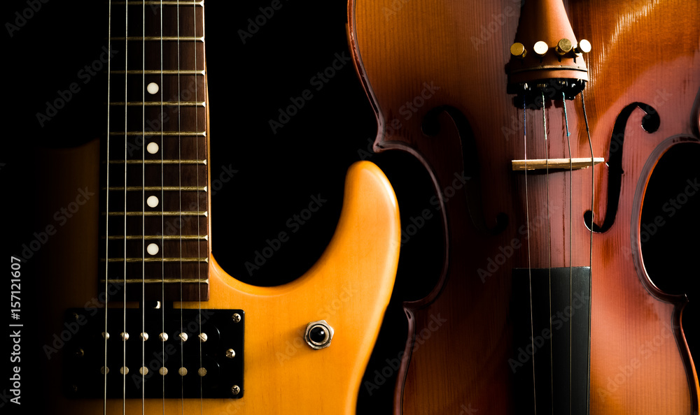 Naklejka premium electric guitar & violin, isolated on black. music background