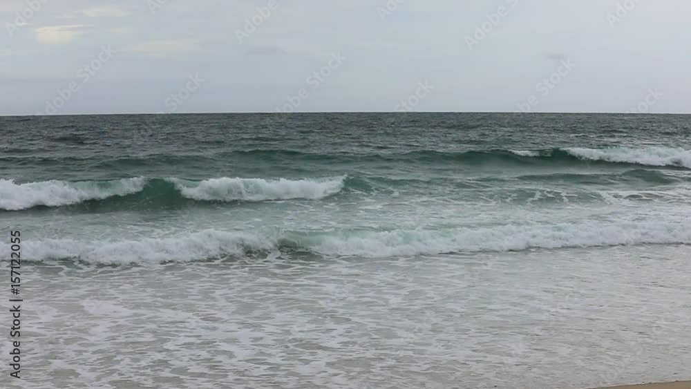 Sea waves on the beach in cloudy weather - slow motion