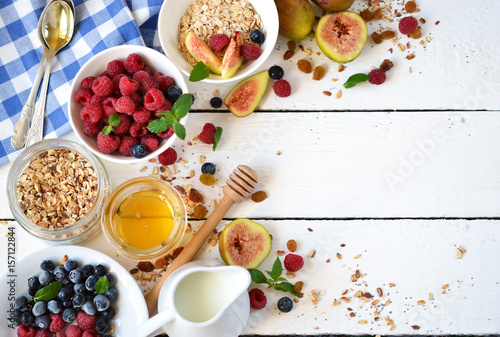 Good morning - granola with honey, berries and fruits. White wooden food background,top view