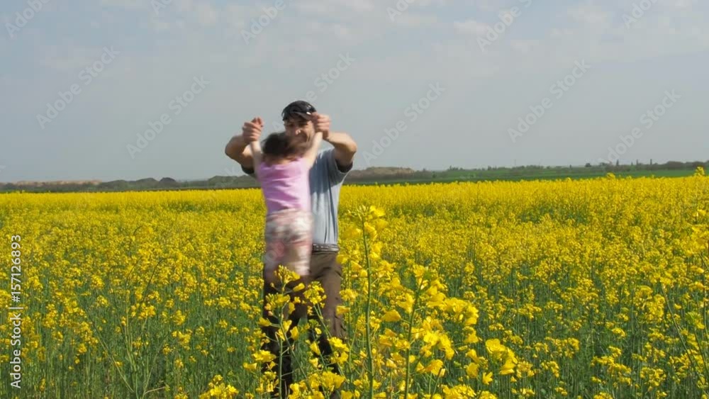 A man is turning a child. Dad turns his daughter in yellow. A happy family. A man is turning a child. Dad turns his daughter in yellow. A happy family.