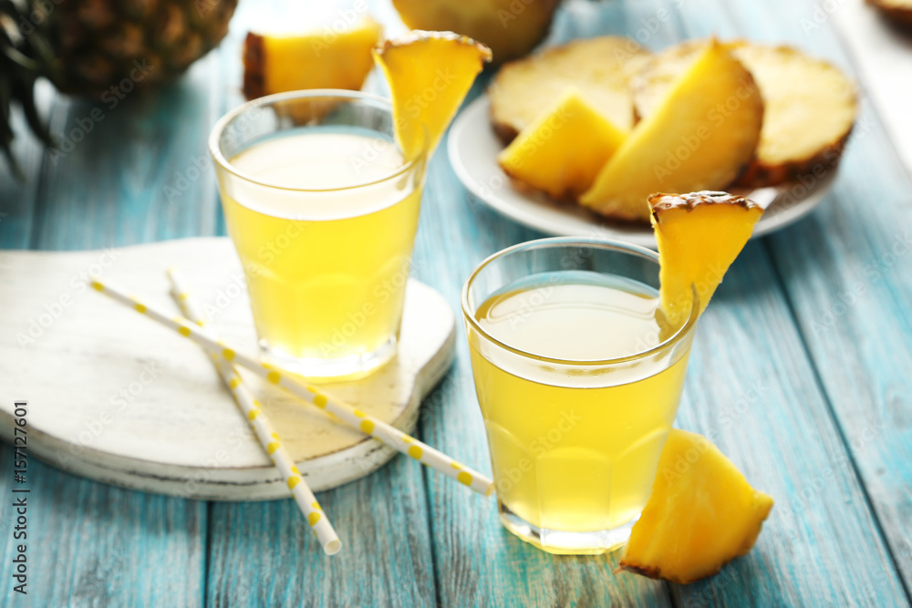 Glasses of pineapple juice on a blue wooden table Glasses of pineapple juice on a blue wooden table