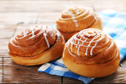 Cinnamon buns with napkin on wooden table