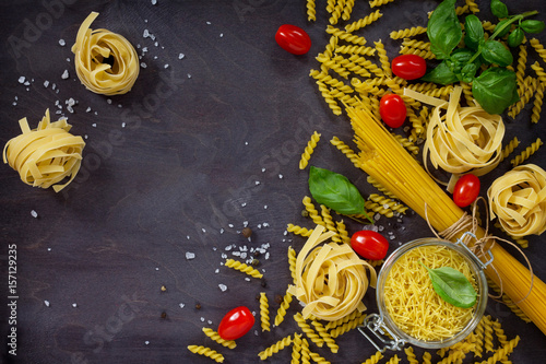 Fotografie, Obraz Ingredients for the preparation of Italian pasta - spaghetti, fusilli, fettuccine, basil, cherry tomato and pepper
