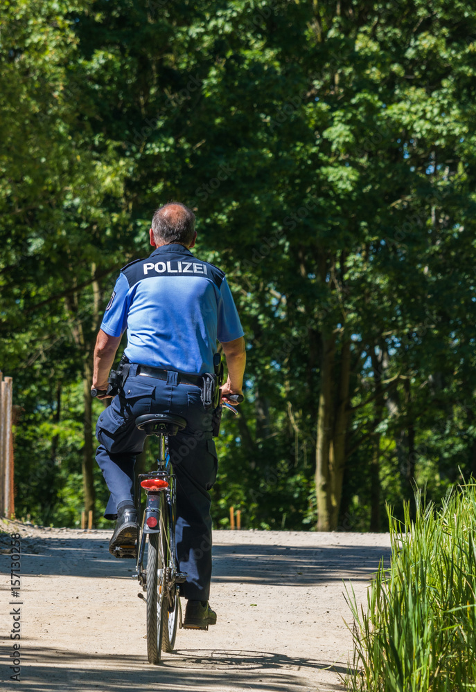 Obraz premium Polizist auf dem Fahrrad unterwegs