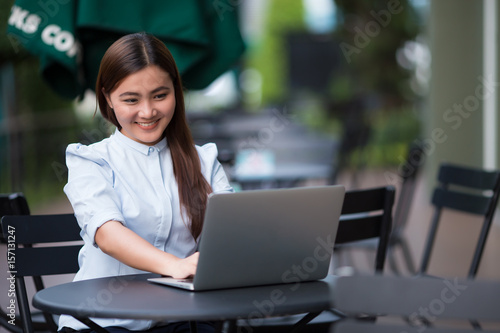 Happy woman using laptop at cafe
