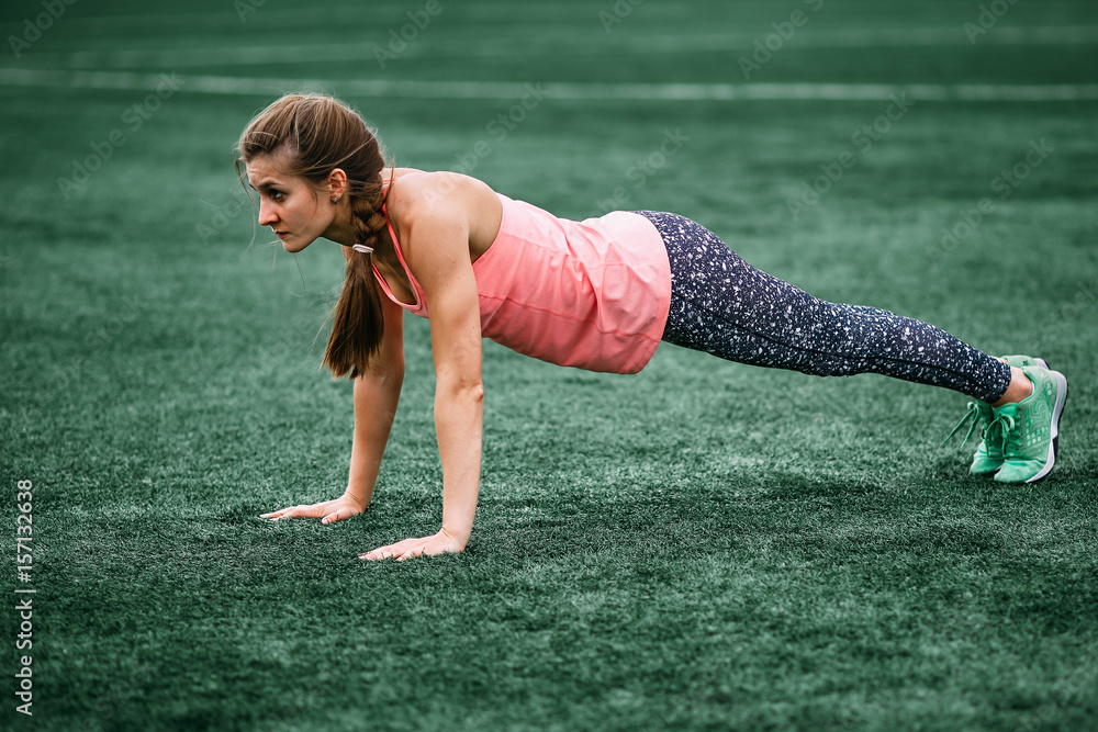 A beautiful muscular girl in tights and a vest makes a warm-up at the  stadium. Cross fit, fitness, healthy lifestyle Stock Photo | Adobe Stock