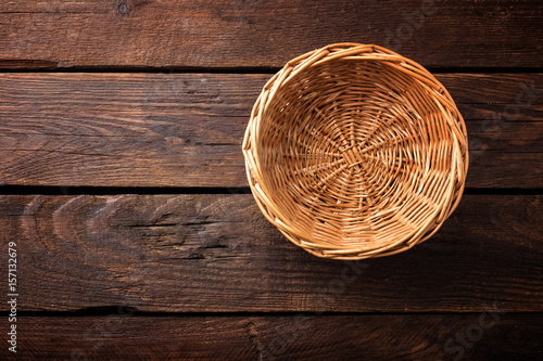 Empty wicker basket on a wooden background, top view