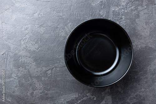 Empty black soup plate on dark grey background, top view