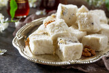 Rahat Lokum with walnuts on the kitchen table. Turkish and Arabic sweets. Ramadan food.
