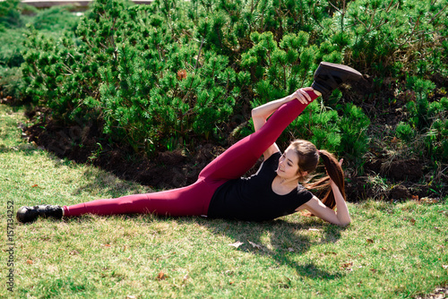 Beautiful girl doing stretching on nature.