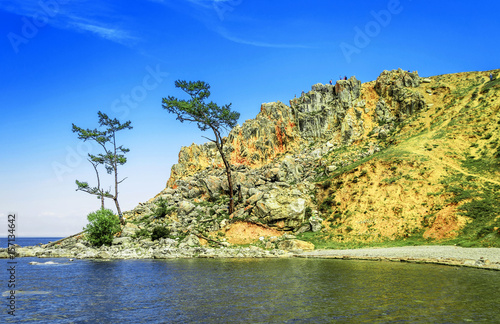 A wonderful view of a rocky cliff with clouds on the horizon with two trees